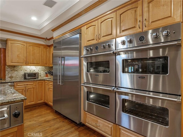 11485 Awenita Ct, Chatsworth, CA 91311 - kitchen with appliances with stainless steel finishes, dark stone counters, ornamental molding, light wood-style flooring, and tasteful backsplash