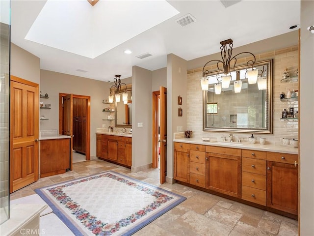 11485 Awenita Ct, Chatsworth, CA 91311 - full bath featuring a chandelier, two vanities, a skylight, backsplash, and stone tile flooring