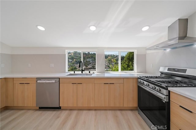 4365 Oneill St, Los Angeles, CA 90032 - kitchen with stainless steel appliances, wall chimney range hood, light brown cabinetry, modern cabinets, and light wood-style floors
