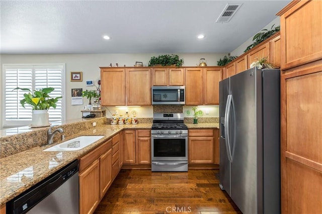 16767 Desert Lily St, Victorville, CA 92394 - kitchen with appliances with stainless steel finishes, dark wood finished floors, light stone countertops, a peninsula, and recessed lighting