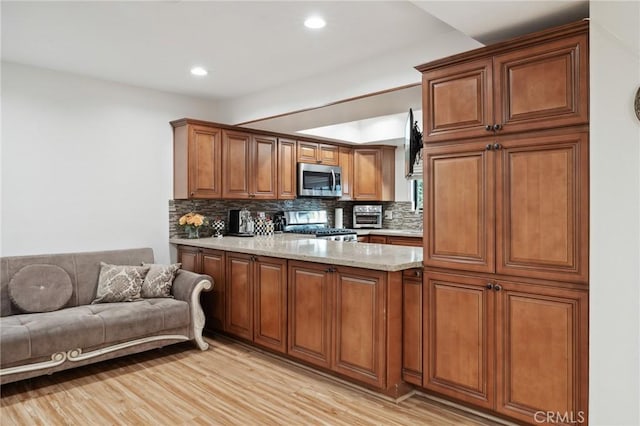 301 W Loraine St Unit 3, Glendale, CA 91202 - kitchen featuring stainless steel appliances, tasteful backsplash, a peninsula, brown cabinets, and recessed lighting