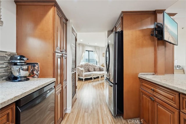 301 W Loraine St Unit 3, Glendale, CA 91202 - kitchen with stainless steel appliances, brown cabinetry, decorative backsplash, light stone counters, and light wood-type flooring