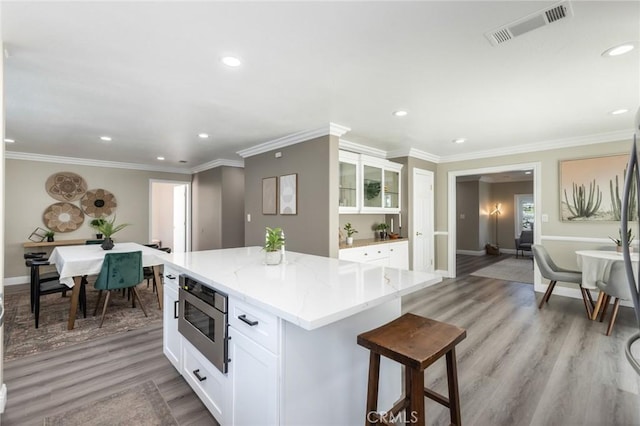2306 255th St, Lomita, CA 90717 - kitchen with white cabinets, light stone countertops, light wood-style flooring, recessed lighting, and ornamental molding