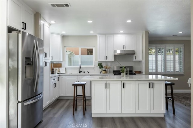 2306 255th St, Lomita, CA 90717 - kitchen with stainless steel refrigerator with ice dispenser, under cabinet range hood, stove, dark wood-type flooring, and white cabinetry