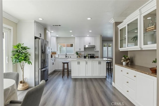 2306 255th St, Lomita, CA 90717 - kitchen featuring stainless steel fridge with ice dispenser, under cabinet range hood, healthy amount of natural light, ornamental molding, and glass insert cabinets