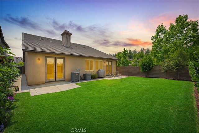 10850 Cameron Ct, Corona, CA 92883 - back of house at dusk featuring a fenced backyard, stucco siding, a patio, a chimney, and a tiled roof