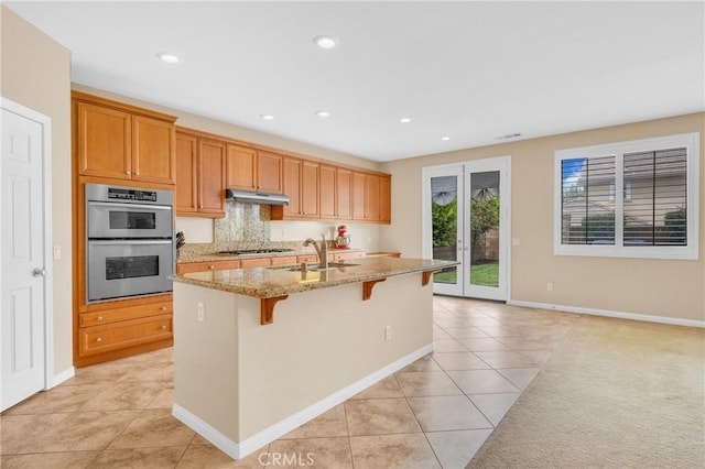 10850 Cameron Ct, Corona, CA 92883 - kitchen with appliances with stainless steel finishes, light tile patterned flooring, a kitchen breakfast bar, a center island with sink, and recessed lighting