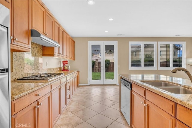 10850 Cameron Ct, Corona, CA 92883 - kitchen with under cabinet range hood, appliances with stainless steel finishes, decorative backsplash, recessed lighting, and light stone counters