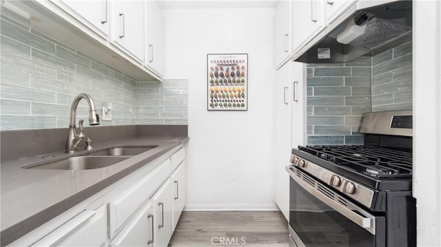 4431 Don Ricardo Dr Unit 20, Los Angeles, CA 90008 - kitchen with gas range, under cabinet range hood, backsplash, white cabinetry, and light wood-style flooring