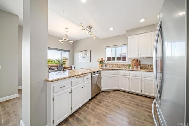 4507 Carnaby Ct, Carlsbad, CA 92010 - kitchen with stainless steel appliances, a chandelier, white cabinets, light stone counters, and recessed lighting