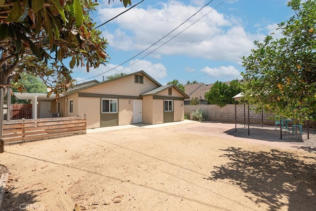 4356 Gardena Dr, Riverside, CA 92506 - view of front of property featuring stucco siding, a fenced backyard, a patio, and a playground