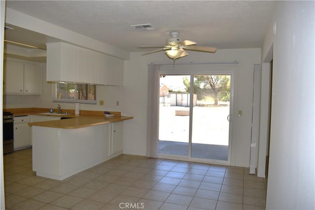 18107 Sycamore St, Hesperia, CA 92345 - kitchen featuring a peninsula, a ceiling fan, white cabinetry, light countertops, and stainless steel range with electric stovetop