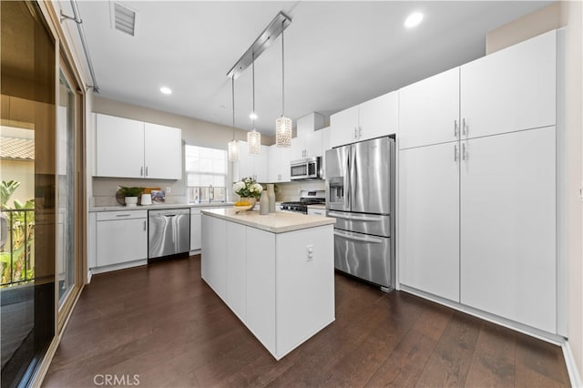 53 Bay Laurel, Irvine, CA 92620 - kitchen with appliances with stainless steel finishes, dark wood finished floors, light countertops, recessed lighting, and white cabinetry