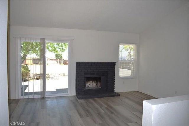 13548 Mount Ranier Way, Hesperia, CA 92345 - unfurnished living room featuring wood finished floors, a brick fireplace, and lofted ceiling