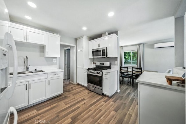 149 S Mistletoe Ave, San Jacinto, CA 92583 - kitchen featuring appliances with stainless steel finishes, a wall mounted AC, white cabinetry, dark wood finished floors, and recessed lighting