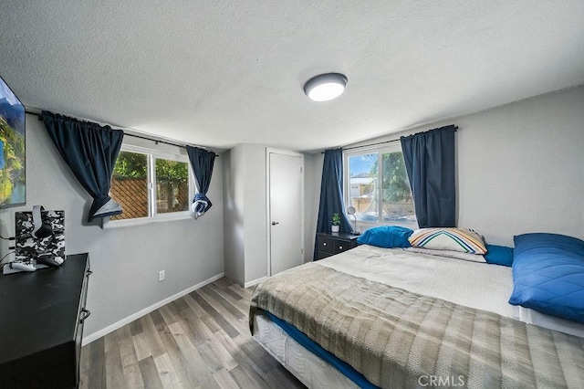 149 S Mistletoe Ave, San Jacinto, CA 92583 - bedroom with wood finished floors, multiple windows, and a textured ceiling