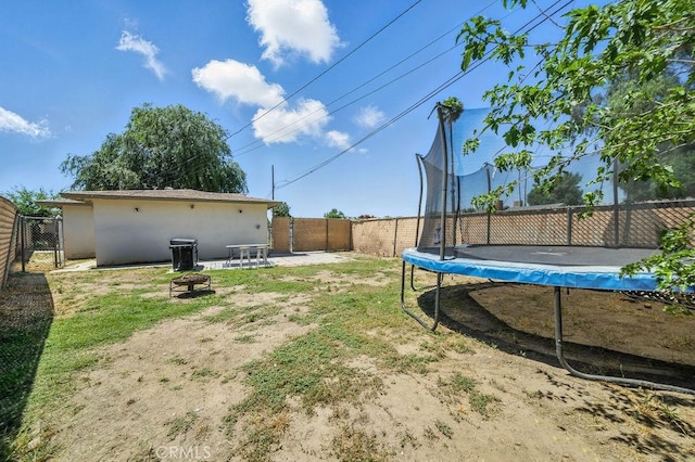 149 S Mistletoe Ave, San Jacinto, CA 92583 - fenced backyard featuring a trampoline and a fire pit