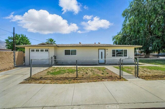 149 S Mistletoe Ave, San Jacinto, CA 92583 - ranch-style house featuring an attached garage, stucco siding, driveway, a fenced front yard, and a gate