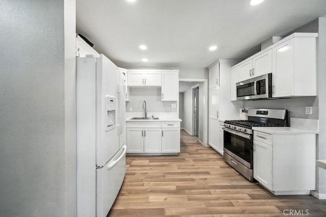 149 S Mistletoe Ave, San Jacinto, CA 92583 - kitchen with stainless steel appliances, recessed lighting, light wood-style floors, white cabinets, and light countertops