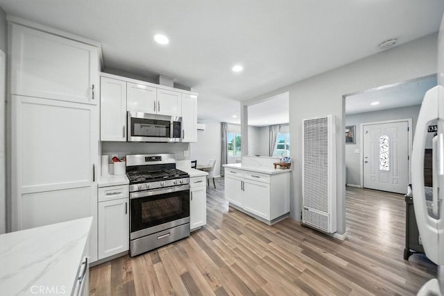149 S Mistletoe Ave, San Jacinto, CA 92583 - kitchen featuring stainless steel appliances, a heating unit, white cabinetry, light wood-type flooring, and recessed lighting