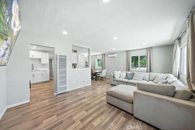 149 S Mistletoe Ave, San Jacinto, CA 92583 - living room featuring a heating unit, an AC wall unit, light wood-style floors, and recessed lighting