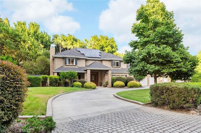 3130 Shady Grove Ct, Chico, CA 95973 - view of front of home with curved driveway, a front lawn, roof mounted solar panels, a chimney, and stucco siding