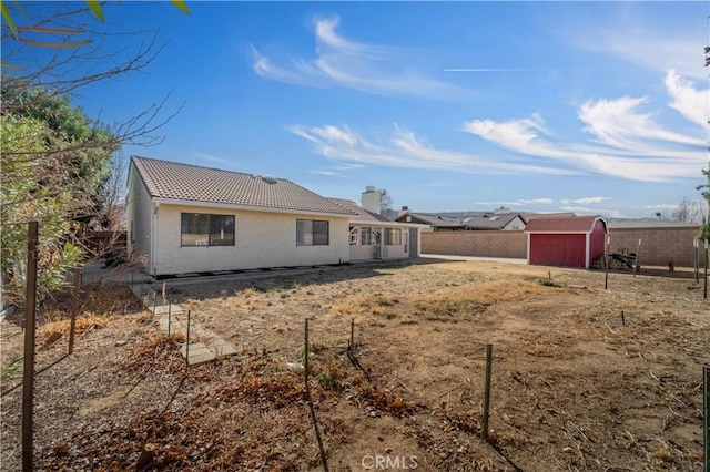 6231 Almond Valley Way, Quartz Hill, CA 93536 - rear view of property with a storage shed, a chimney, stucco siding, and a tiled roof