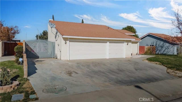 6231 Almond Valley Way, Quartz Hill, CA 93536 - view of front of property with a tile roof, stucco siding, a gate, concrete driveway, and an attached garage