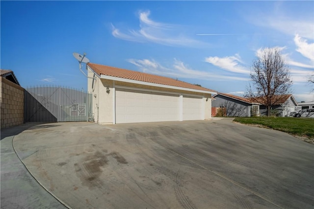 6231 Almond Valley Way, Quartz Hill, CA 93536 - view of home's exterior with a gate, a garage, a tiled roof, and stucco siding