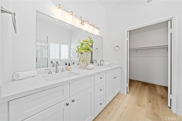575 E Nubia St, Covina, CA 91722 - bathroom with a stall shower, double vanity, wood finished floors, and a walk in closet