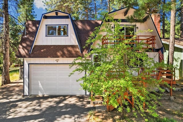 2616 Secret Dr, Running Springs, CA 92382 - a-frame home featuring a shingled roof, a chimney, a gambrel roof, board and batten siding, and a garage