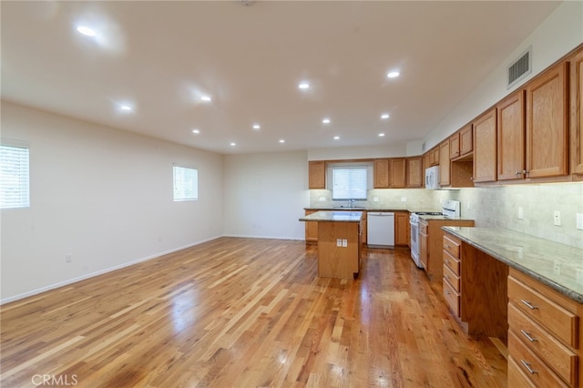 10838 Burnet Ave, San Fernando, CA 91345 - kitchen with white appliances, a center island, backsplash, light wood finished floors, and recessed lighting
