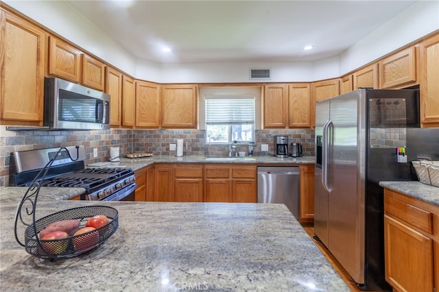 10838 Burnet Ave, San Fernando, CA 91345 - kitchen featuring stainless steel appliances, backsplash, and light stone counters