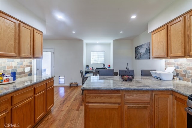 10838 Burnet Ave, San Fernando, CA 91345 - kitchen featuring a peninsula, tasteful backsplash, light wood-type flooring, light stone counters, and recessed lighting