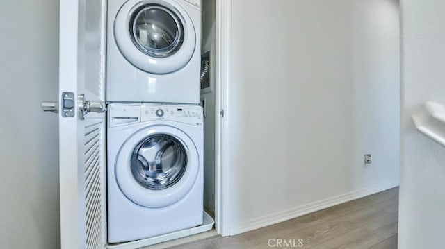 17554 Waterfall Ct, Fountain Valley, CA 92708 - washroom with stacked washing machine and dryer and wood finished floors