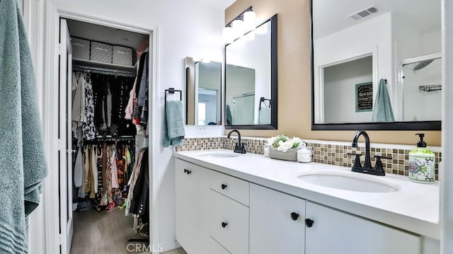 17554 Waterfall Ct, Fountain Valley, CA 92708 - full bathroom with double vanity, a walk in closet, wood finished floors, decorative backsplash, and a shower