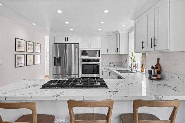 2017 Curtis Ave Unit B, Redondo Beach, CA 90278 - kitchen with appliances with stainless steel finishes, light stone countertops, a peninsula, white cabinetry, and recessed lighting