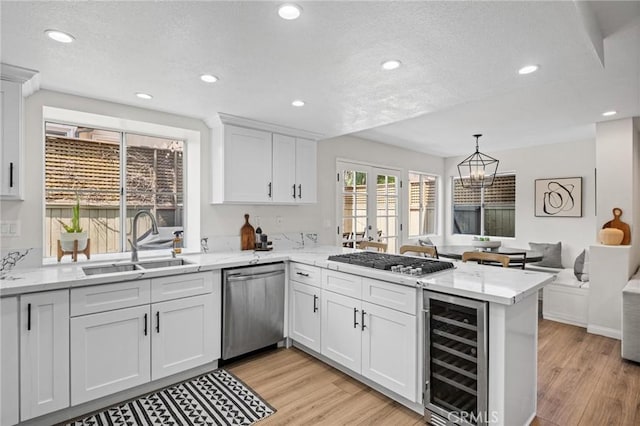 2017 Curtis Ave Unit B, Redondo Beach, CA 90278 - kitchen featuring beverage cooler, appliances with stainless steel finishes, a peninsula, a textured ceiling, and white cabinetry