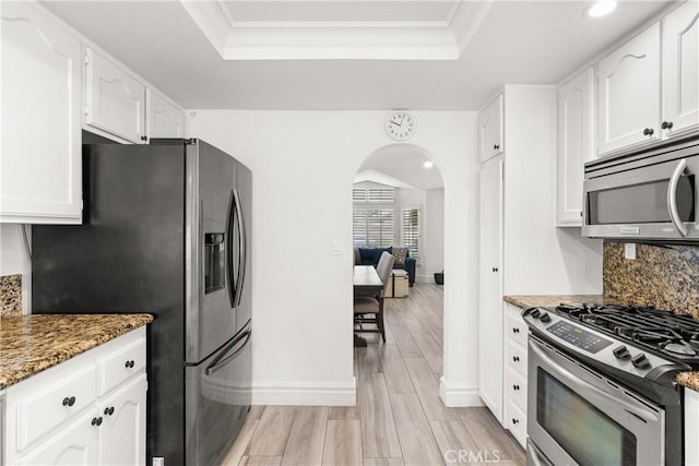 5650 Harvest Way, Yorba Linda, CA 92886 - kitchen with stainless steel appliances, arched walkways, a tray ceiling, tasteful backsplash, and white cabinetry