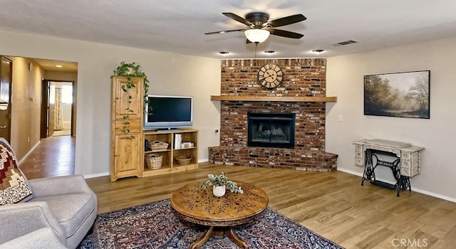 15381 Otomian Rd, Apple Valley, CA 92307 - living room with a ceiling fan, wood finished floors, and a brick fireplace