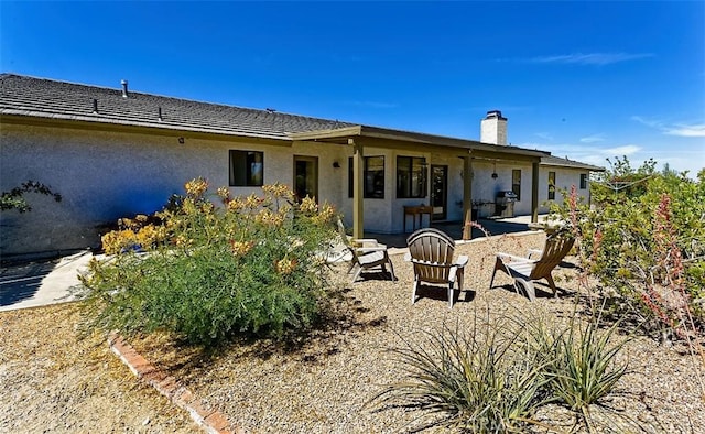 15381 Otomian Rd, Apple Valley, CA 92307 - back of house featuring a patio, stucco siding, and a chimney