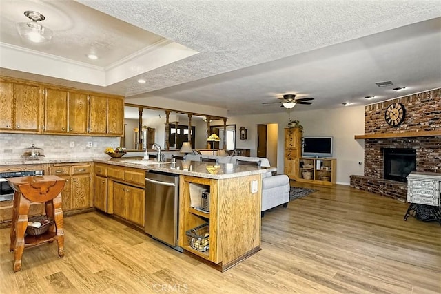 15381 Otomian Rd, Apple Valley, CA 92307 - kitchen featuring stainless steel appliances, a peninsula, brown cabinetry, light wood-type flooring, and a raised ceiling