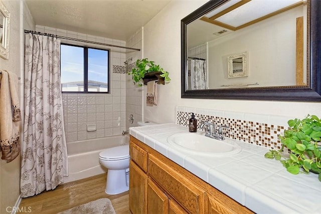 15381 Otomian Rd, Apple Valley, CA 92307 - bathroom featuring wood finished floors, vanity, shower / bath combo with shower curtain, and decorative backsplash