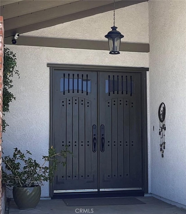 15381 Otomian Rd, Apple Valley, CA 92307 - doorway to property with stucco siding and a surveillance system