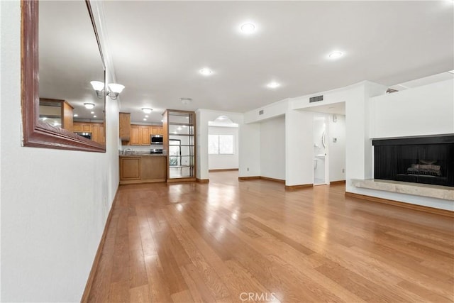 7137 Shoup Ave Unit 39, West Hills, CA 91307 - unfurnished living room featuring light wood-style flooring, a fireplace with raised hearth, and recessed lighting