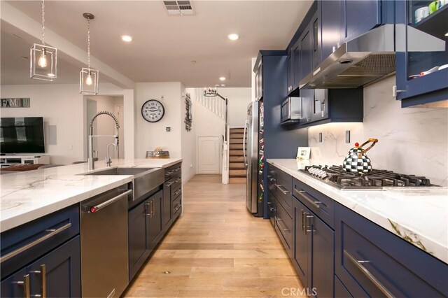 19680 Griffith Dr, Saugus, CA 91350 - kitchen with appliances with stainless steel finishes, exhaust hood, light wood-style flooring, light stone countertops, and decorative backsplash