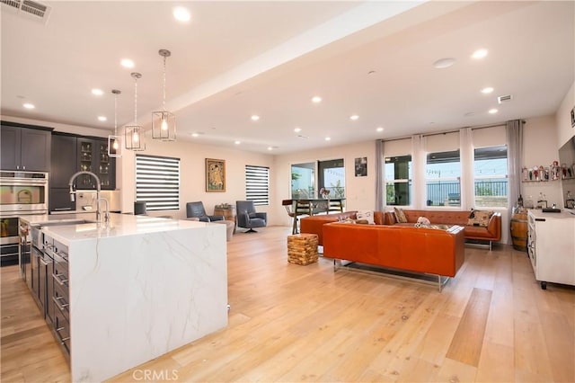 19680 Griffith Dr, Saugus, CA 91350 - kitchen with double oven, open floor plan, recessed lighting, healthy amount of natural light, and a kitchen island with sink