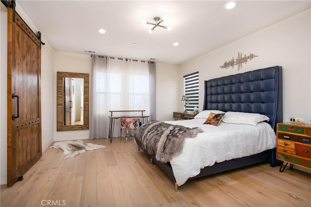 19680 Griffith Dr, Saugus, CA 91350 - bedroom with light wood finished floors, a barn door, and recessed lighting