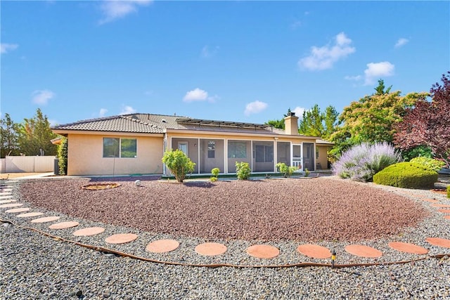 14908 Dakota Rd, Apple Valley, CA 92307 - ranch-style home with a sunroom, roof mounted solar panels, a tiled roof, stucco siding, and a chimney