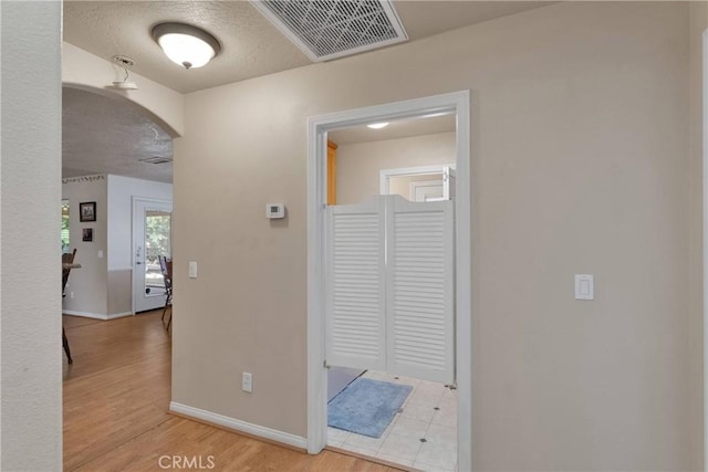 14908 Dakota Rd, Apple Valley, CA 92307 - hall featuring arched walkways, light wood-style floors, and a textured ceiling